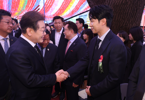 李在明大統領選候補と握手を交わしているイ・スンギさん。［写真　大統領室写真記者団］