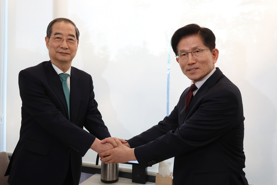 金文洙（キム・ムンス）与党「国民の力」大統領選挙候補と韓悳洙（ハン・ドクス）無所属予備候補が７日午後、ソウル鍾路区（チョンノグ）のある飲食店で単一化関連の会合を行う前に握手をしている。キム・ソンリョン記者