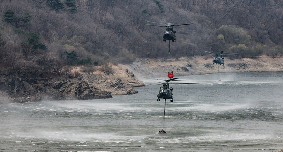 山火事鎮火のために水を汲み取っている韓国陸軍「チヌーク」ヘリコプター。［写真　聯合ニュース］