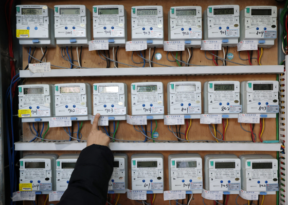 昨年１２月２３日、ソウル市内の多世帯住宅で管理人が世帯別に電気メーターを調べている。［写真　ニュース１］