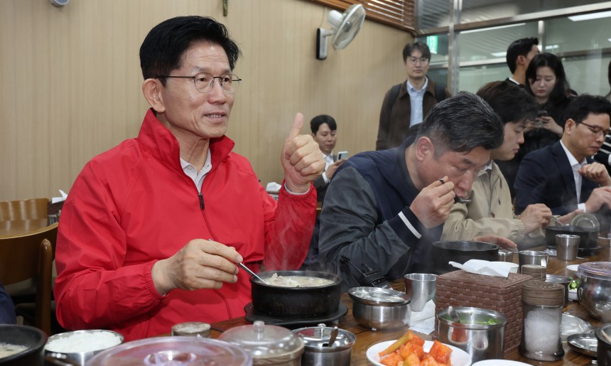 第２１代大統領選挙公式選挙運動初日の１２日、与党「国民の力」金文洙（キム・ムンス）大統領候補がソウル松坡区（ソンパグ）の可楽市場（カラクシジャン）を訪れて商人たちとスンデクッパを食べて話を交わしている。［写真　聯合ニュース］