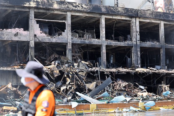 クムホタイヤ光州工場の火災発生２日目だった１８日、燃えた工場の前に消防隊員が移動している。［写真　聯合ニュース］