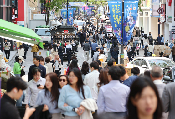 今年４月、ソウル明洞（ミョンドン）を歩く市民と外国人観光客。［写真　聯合ニュース］