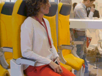 飛行機の立ち席「スカイライダー」に座っている乗客。［動画　アビオインテリアズ］ ​