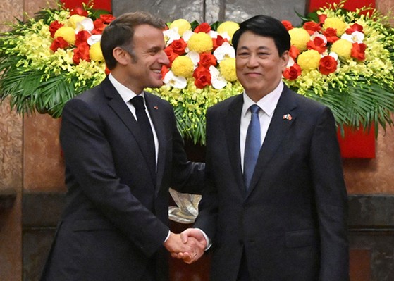 原発セールスに出たフランスのマクロン大統領（左）が２６日にハノイの主席府でベトナムのルオン・クオン国家主席と握手している。ベトナムは原発開発を推進中だ。［写真　ＡＰ＝聯合ニュース］