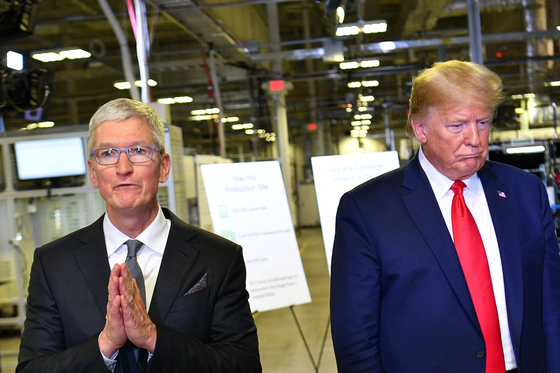 ２０１９年にトランプ米大統領（右）とアップルのティム・クックＣＥＯがテキサスのコンピュータ生産施設をともに訪問した様子。［写真　ＡＦＰ＝聯合ニュース］