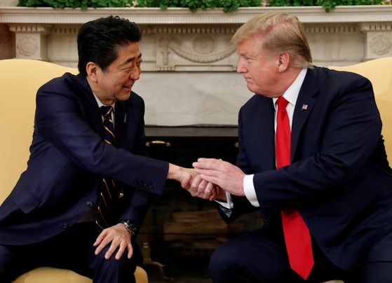 ２０１９年４月２６日（現地時間）、米ホワイトハウスで握手するトランプ大統領（右）と安倍晋三首相　［ロイター＝聯合ニュース］
