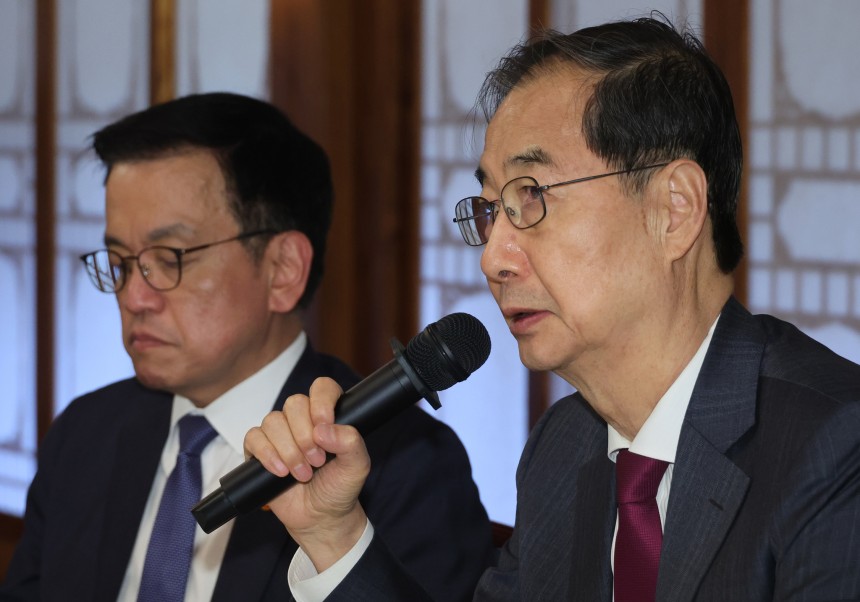 韓悳洙前首相（右）と崔相穆前副首相兼企画財政部長官。［写真　聯合ニュース］