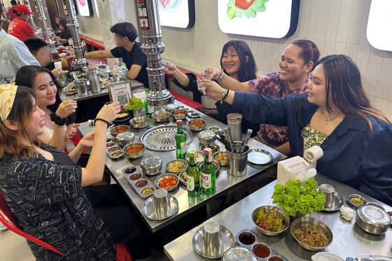 １９日（現地時間）、フィリピン・マニラの韓国式焼肉店「サムギョプサルラマッ」で現地の客が韓国の焼酎を飲んでいる。［写真　ハイト眞露］