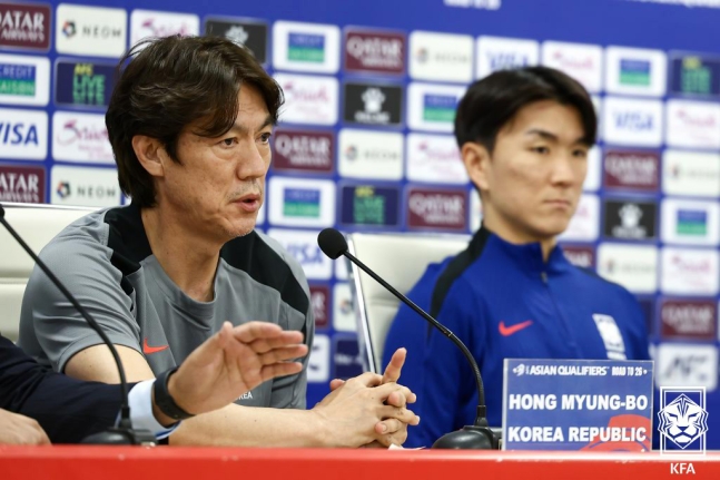 イラクのバスラ国際競技場で行われた北中米Ｗ杯アジア３次予選の公式記者会見で発言する韓国代表の洪明甫（ホン・ミョンボ）監督。右は黄仁範（ファン・インボム）。　［写真　ＫＦＡ］