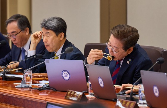 李在明（イ・ジェミョン）大統領が５日、竜山（ヨンサン）大統領室で主宰した最初の国務会議の途中で昼食にのり巻き（キムパプ）を食べている。この日の会議には李周浩（イ・ジュホ）首相職務代行兼副総理（中央）をはじめ、趙兌烈（チョ・テヨル）外交部長官（左）、劉相任（ユ・サンイム）科学技術情報通信部長官など尹錫悦（ユン・ソクヨル）政府の時に任命された国務委員が多数参加した。［写真　韓国大統領室］