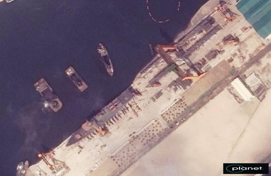 先月２１日、北朝鮮が金正恩国務委員長が見守る中、新しく建造した５０００トン級駆逐艦の進水式を開いたが、進水過程で駆逐艦が横倒しになって破損する事故が発生した。写真は同月１５日に撮影された清津造船所で建造を終えて進水を準備する駆逐艦の衛星写真。　［写真　韓国統一部提供］