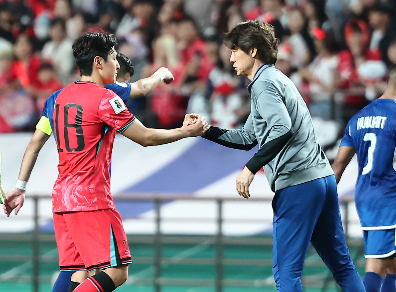 サッカー韓国代表の李康仁（イ・ガンイン、左）と洪明甫（ホン・ミョンボ）監督が握手している。　［写真　ニュース１］