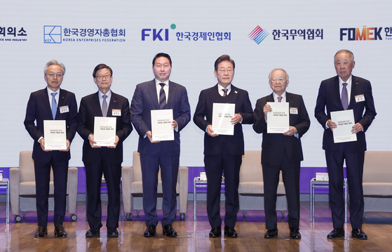 ５月８日、ソウル中区（チュング）大韓商工会議所で開かれた李在明（イ・ジェミョン）共に民主党大統領選候補が招待する経済５団体懇談会で、李在明氏が経済５団体長から政策提言集を手渡された後、記念撮影をしている。左側から韓国中堅企業連合の崔鎮植（チェ・ジンシク）会長、韓国貿易協会の尹鎭植（ユン・ジンシク）会長、大韓商工会議所の崔泰源（チェ・テウォン）会長、李氏、韓国経営者総協会の孫京植（ソン・ギョンシク）会長、韓国経済人協会の柳津（リュ・ジン）会長。［写真　国会写真記者団］