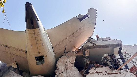１２日に２４２人を乗せたエア・インディアの旅客機がアーメダバード国際空港近くの住宅地に墜落した。旅客機の尾翼部分が墜落後に衝突し建物に刺さっている。［写真　ＡＦＰ＝聯合ニュース］