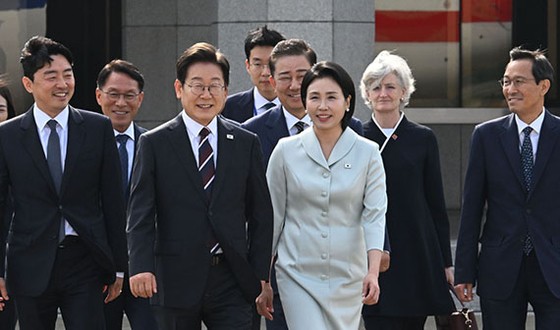 カナダＧ７首脳会議に参加する李在明大統領が１６日、ソウル空港に歓送にきた人たちと移動している。左から姜勲植秘書室長、ファン・イングォン警護処長、李大統領、通訳担当行政官、金炳基「共に民主党」院内代表、金恵景夫人、マウヒニー駐韓カナダ大使、禹相虎政務首席秘書官。キム・ヒョンドン記者