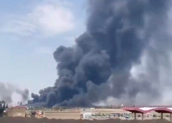 イスラエルが１３日、イランの核施設と主要軍事施設を攻撃した。写真はイラン北部タブリーズ国際空港付近の軍事施設で黒い煙が広がる場面。［写真　ロイター＝聯合ニュース］