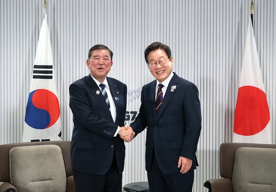 李在明（イ・ジェミョン）大統領と石破茂首相が１７日（現地時間）、カナダ・アルバータ州カナナスキスＧ７サミット会場で行われた韓日首脳会談で握手している。　［大統領室写真記者団］