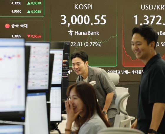 ＫＯＳＰＩが取引場で３０００を超えた２０日、ソウル中区（チュング）のハナ銀行ディーリングルームでディーラーが対話している。　［聯合ニュース］
