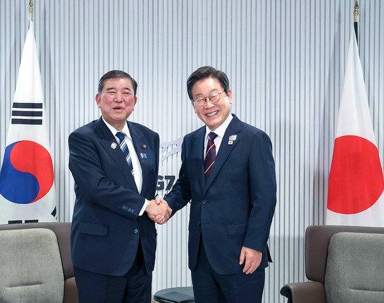 李在明大統領と石破茂首相が１７日にカナダのカナナスキスで開かれた韓日首脳会談で握手を交わしている。［写真　大統領室写真記者団］