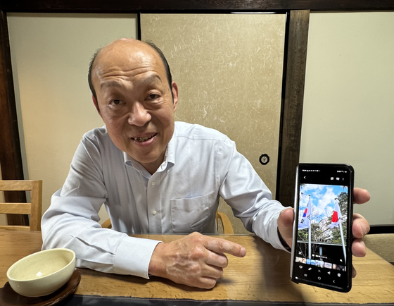 ６日、鹿児島県美山で会った１５代沈寿官が携帯電話で撮影した両国の国旗を見せている。彼は風が吹けば同じ方向にはためく太極旗と日章旗を見るとうれしくなると語った。　キム・ヒョンイェ特派員