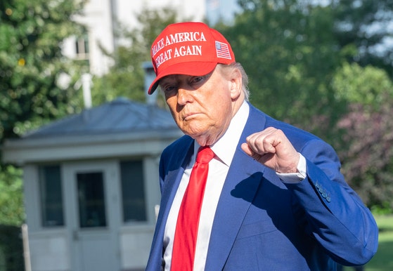 ２１日に米ニュージャージー州からワシントンＤＣのホワイトハウスに到着したトランプ米大統領が取材陣に向け拳を握って見せている。〔写真　ＥＰＡ＝聯合ニュース〕