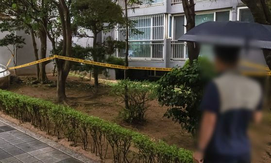 ２１日午前、高校生３人が飛び降りて遺体で発見された釜山（プサン）のあるマンションの花壇。２２日、警察がポリスラインで出入りを統制している。ソン・ボングン記者　