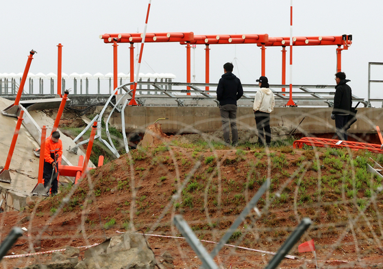 今年４月２２日、全羅南道務安（チョルラナムド・ムアン）国際空港でチェジュ航空旅客機事故の原因を調べている航空鉄道事故調査委員会関係者らが、ローカライザー施設の現場調査を行っている。［写真　聯合ニュース］