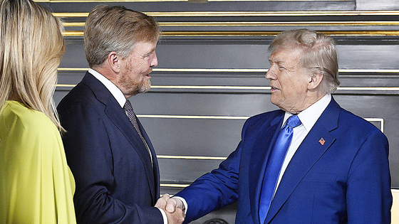 米国のドナルド・トランプ大統領（右）がオランダ・ハーグで開かれる北大西洋条約機構（ＮＡＴＯ）首脳会議を控えてオランダのウィレム＝アレクサンダー国王と会って握手を交わしている。左はマクシマ王妃。［写真　ＡＰ＝聯合ニュース］