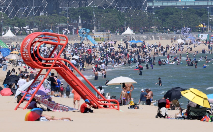 ２９日午後、釜山の海雲台海水浴場で避暑客が水遊びをしながら暑さをしのいでいる。［写真　聯合ニュース］