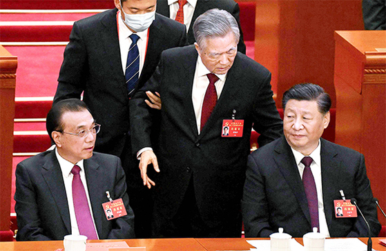 中国共産党第２０回全国代表大会閉幕式で退席させられる胡錦濤前国家主席。［写真　ＡＦＰ＝聯合ニュース］