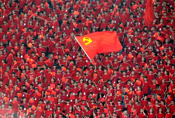 ２０１１年６月２９日、中国共産党創党９０周年を控えて重慶市オリンピック（五輪）スポーツセンターで開かれた革命歌謡合唱大会開幕式で学生たちがマスゲームを繰り広げている。［写真　ロイター＝聯合ニュース］