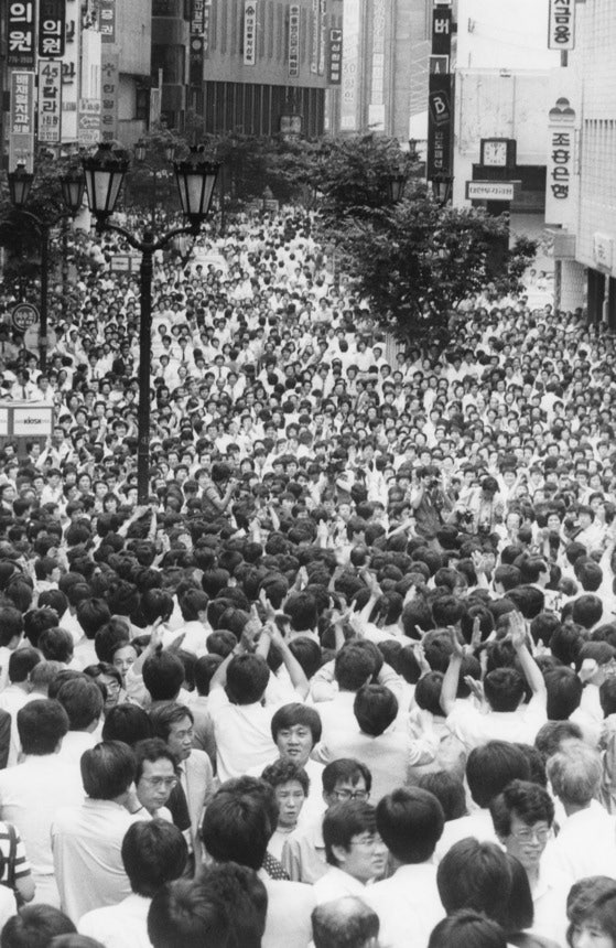 １９８７年６月１５日の昼休み。ソウル・明洞の通りに会社員らがあふれデモを行っている。［中央フォト］