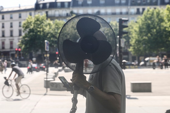 先月３０日（現地時間）、ある男性が扇風機を手にしてフランス・パリ市内を歩いている。［写真　ＥＰＡ＝聯合ニュース］