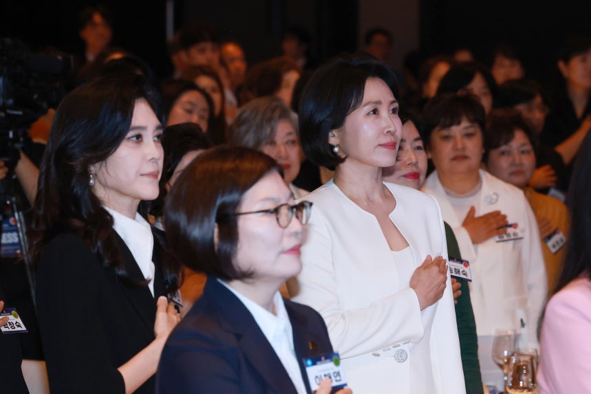 李在明大統領の妻の金恵景夫人が１日にソウル市内のホテルで開かれた第４回女性企業週間開会式に参加し国旗に敬礼している。左側はホテル新羅の李富真社長。［写真　聯合ニュース］