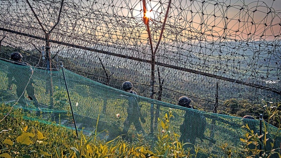 京畿道漣川郡（ヨンチョングン）中西部前線のＤＭＺで、陸軍第２８師団の将兵が南方限界線の鉄柵に沿って施設を点検しながら移動している。［聯合ニュース］