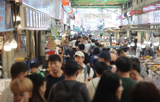 韓国政府が民生回復消費クーポン１次支給計画を発表した翌日の６日、ソウル市内の伝統市場を訪れた市民が店を見回している。景気振興に向けた李在明政権初の民生回復消費クーポン申請と支給が２１日から９月１２日まで８週間にわたり進められる。［写真　聯合ニュース］
