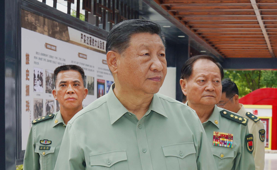 昨年１０月１７日、中国の習近平主席（中央）が中央軍事委員会の張又侠・副主席（右）と方永祥・公務処理庁主任（左）の随行を受けてロケット軍旅団を視察している。［写真　新華＝聯合ニュース］