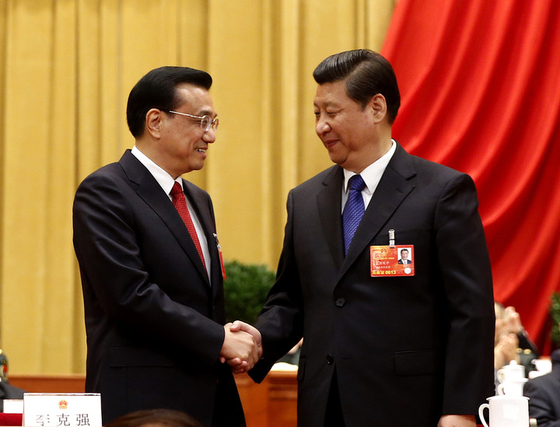 握手を交わす李克強と習近平。［写真　新華社通信］