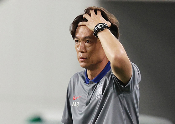   韓日戦の試合運びがうまくいかず頭を抱える洪明甫サッカー韓国代表チーム監督。［写真　ニューシス］