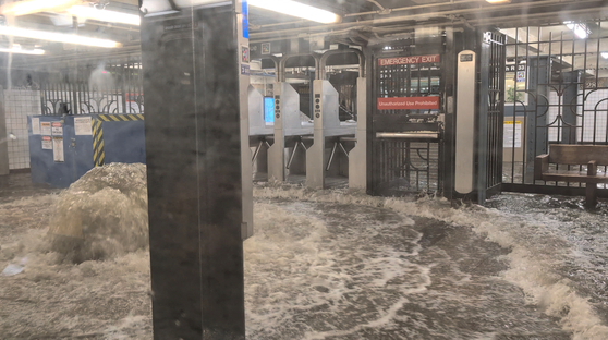 記録的な大雨が降りニューヨーク市地下鉄駅舎が浸水した様子。［写真　ロイター＝聯合ニュース］