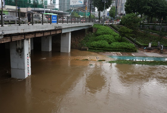 突風と雷・稲妻を伴う強い雨が降る１７日、ソウル西大門区繒山橋の下部道路が全面通行止めとなっている。［写真　聯合ニュース］