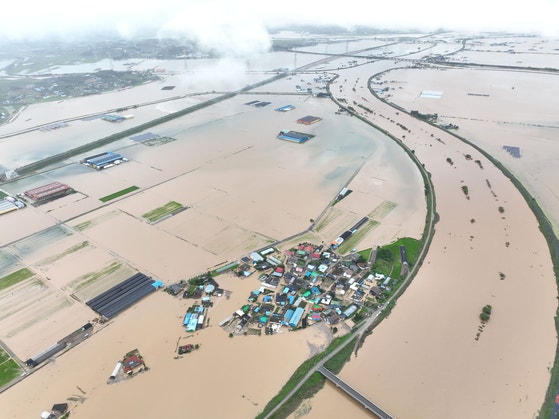 忠南（チュンナム）地域一帯に１６～１７日の２日間で５００ミリを超える集中豪雨が降る中、１７日、忠清南道礼山郡挿橋邑龍洞３里（イェサングン・サプギョウプ・ヨンドンサムリ）一帯の集落が濁流に沈んでいる。韓国気象庁は１８～１９日にも南部地方を中心に４００ミリ以上の降水量が予想されると発表した。［写真　聯合ニュース］