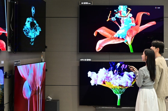 ＬＧエレクトロニクスのベストショップでモデルが２０２５年型ＯＬＥＤ　Ｅｖｏ新製品を鑑賞している。　［写真　ＬＧエレクトロニクス］