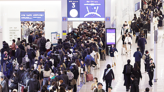 旧正月連休の仁川国際空港第１旅客ターミナルの出国ロビーで乗客が搭乗手続きのために列を作っている。［写真　聯合ニュース］