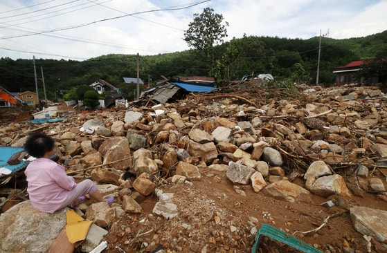 ２０日、慶尚南道山清郡山清邑のウェジョン村のある住民が、石畑に変わった村を眺めながら呆然としている。１６日から「極限豪雨」が降った山清郡では土砂崩れと浸水が相次ぎ、１０人が死亡し、４人が行方不明になる人命被害まで発生した。［写真　ニュース１］