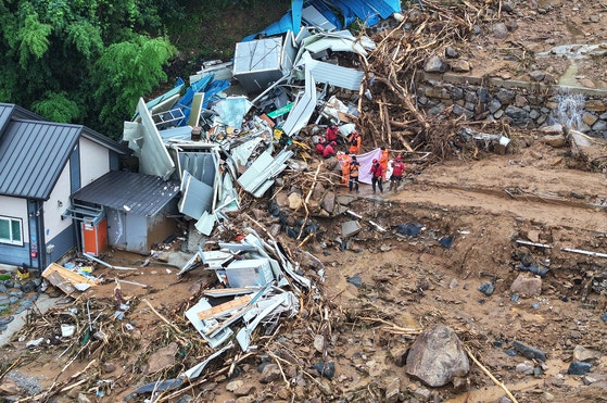 ２０日午前、慶南山清邑の土砂災害現場で消防隊員など関係者が行方不明者捜索作業をしている。　［ニュース１］