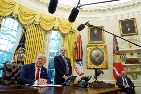 ２月にトランプ米大統領（左）がホワイトハウスで大統領令に署名する様子をウォール・ストリート・ジャーナルの親会社ニューズ・コーポレーションのオーナー、ルパート・マードック氏（右）が見守っている。［写真　ＡＰ＝聯合ニュース］