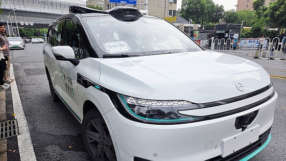 中国湖北省武漢市のある道路に停車中の百度の第６世代ロボタクシー「ＲＴ６」の様子。車両上部には自動運転関連の部品が角のように飛び出ていた以前の世代とは異なり、一部の部品が一体化した形で装着されている。百度によると、生産単価も前世代の車両より５０％以上おさえ、大量生産および商用化にさらに一歩近づいたという。ユン・ジョンミン記者
