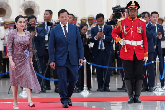 ４月、カンボジアのフン・マネット首相（真ん中）がタイのシナワット首相（左）とカンボジア・プノンペンの平和宮殿を歩いている。　［聯合ニュース］